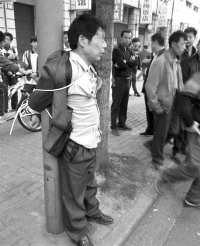 男子被绑在灯柱上示众 男子被绑在灯柱上示众