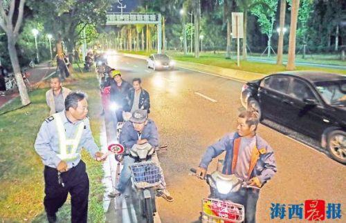 隧道安保员对将闯云顶隧道的电动车骑手进行劝导。记者 陈理杰 摄