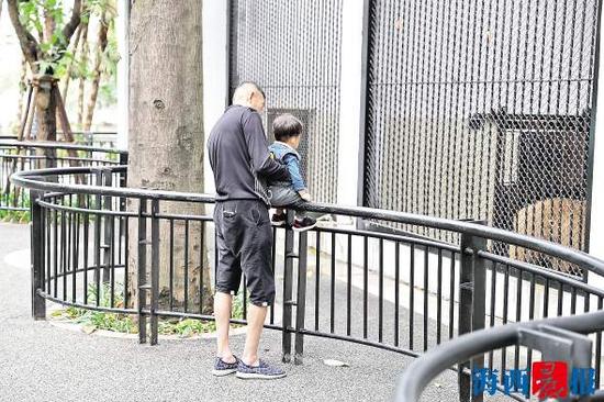 家长抱着孩子坐上护栏