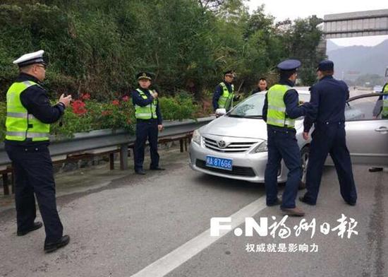 交通执法人员和高速交警联手拦截非法营运车。