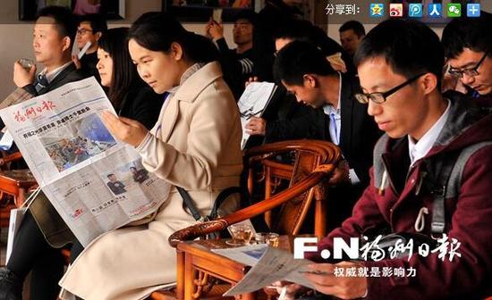 博士们利用参观的间歇阅读本报报道。记者 郑帅 摄