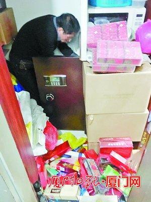 店主从角落里的保险箱内取出假烟及走私烟。