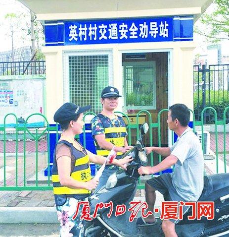 ▲劝导员在出村口拦车劝导。