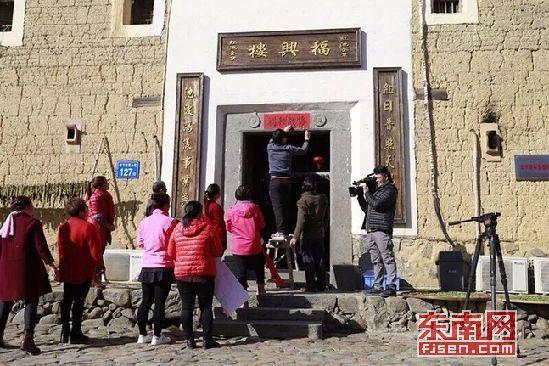 剧组拍摄土楼居民贴春联场景