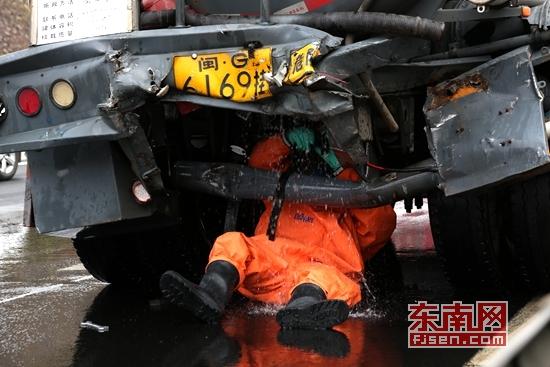 身穿防化服的消防官兵正对槽罐车进行堵漏处置