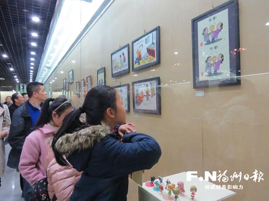 群众在参观移风易俗漫画展。(资料图)